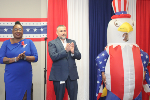 A woman and man in formal wear stand beside an Uncle Sam inflatable.