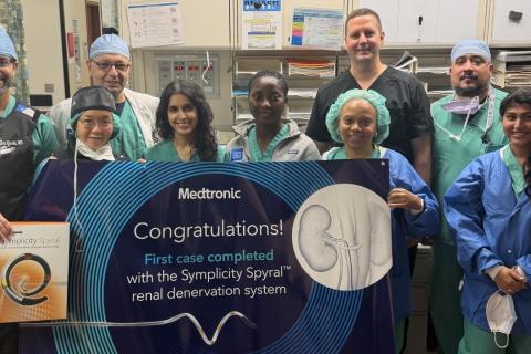 Group of medical professionals in scrubs holding a sign that says "Congratulations!"